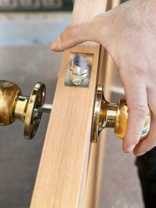 Install interior door, joiner mount knob with lock, hand close-up.