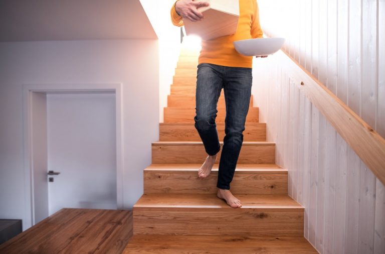 person coming down stairs with a box in the hands