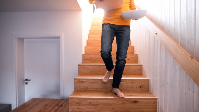 person coming down stairs with a box in the hands