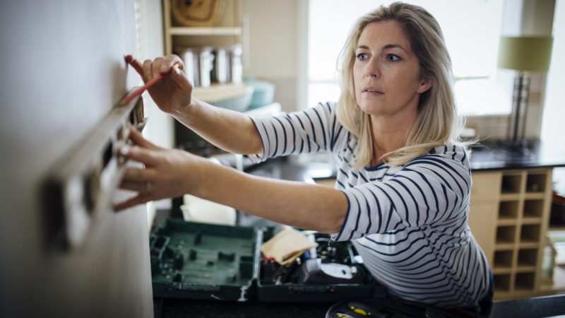 Woman using a spirit level to help with DIY