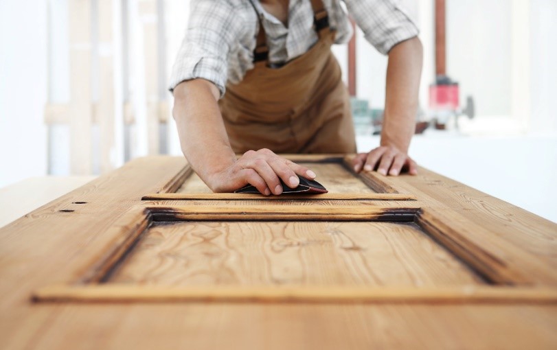 Man sanding down a bespoke wooden door