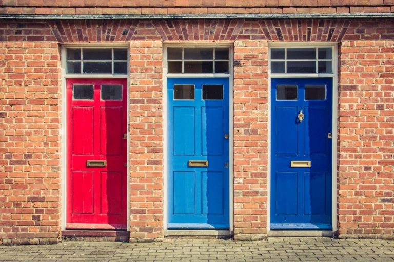 Beautiful wooden doors in a line in red, light blue, and dark blue