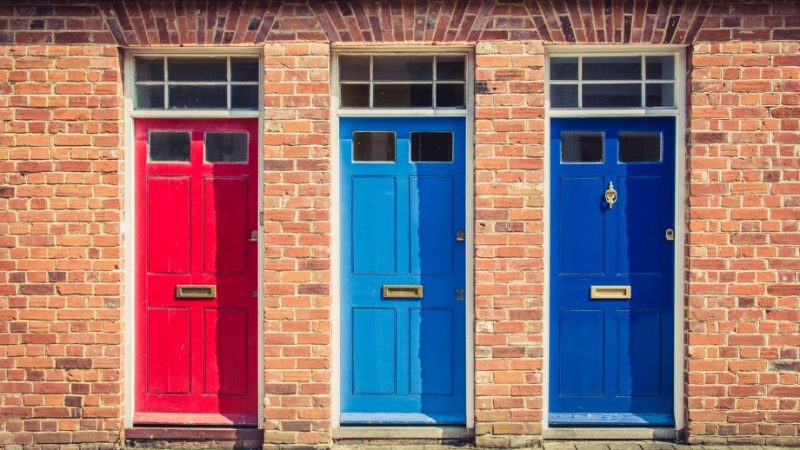 Beautiful wooden doors in a line in red, light blue, and dark blue