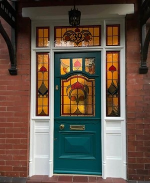 Stunning traditional teal wooden door with stained glass windows surrounding