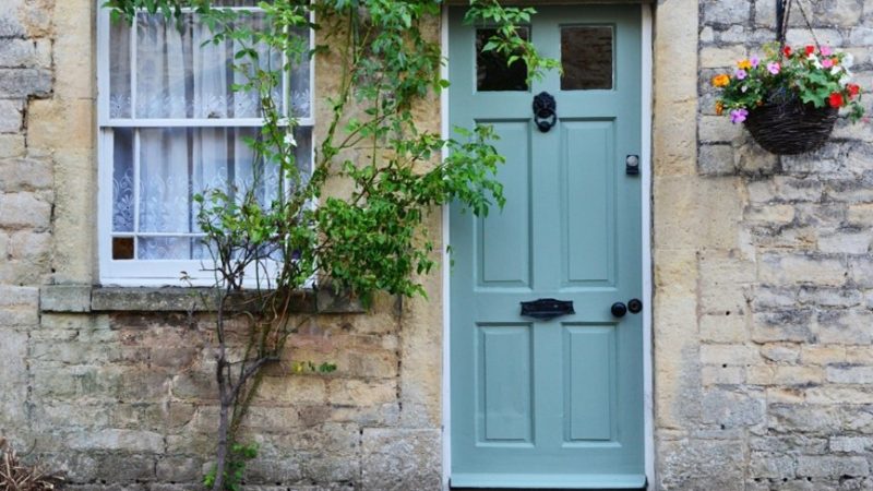 Stunning wooden teal door on a beautiful cottage