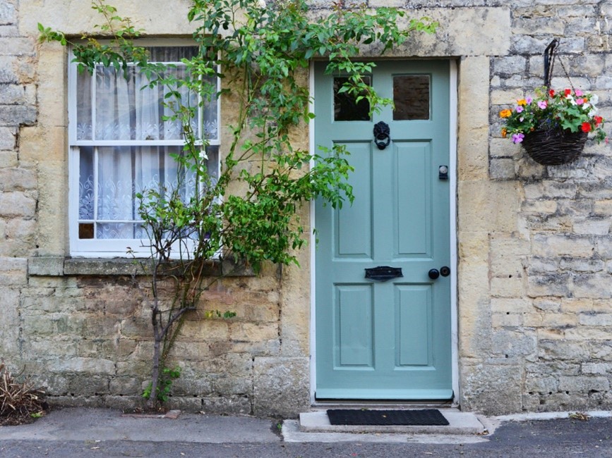 Stunning wooden teal door on a beautiful cottage