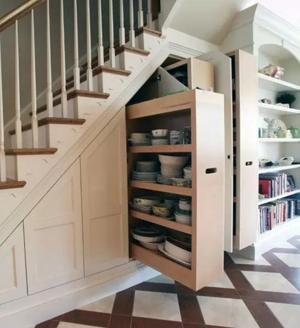 A staircase that has a hidden cupboard built in. The cupboard has multiple bowls and dishes on the shelves.