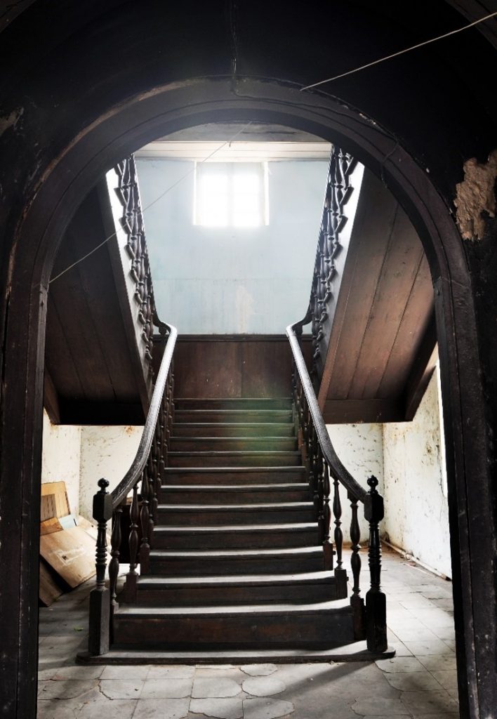 A grand wooden staircase that breaks off into two separate staircases. 