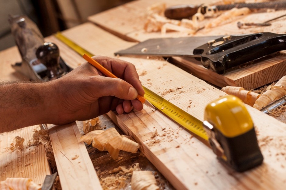 a joiner measuring a plank of wood